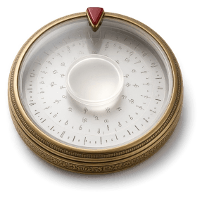 A brass-and-glass cipher wheel with engraved glass discs and a small deep-red enamel pointer